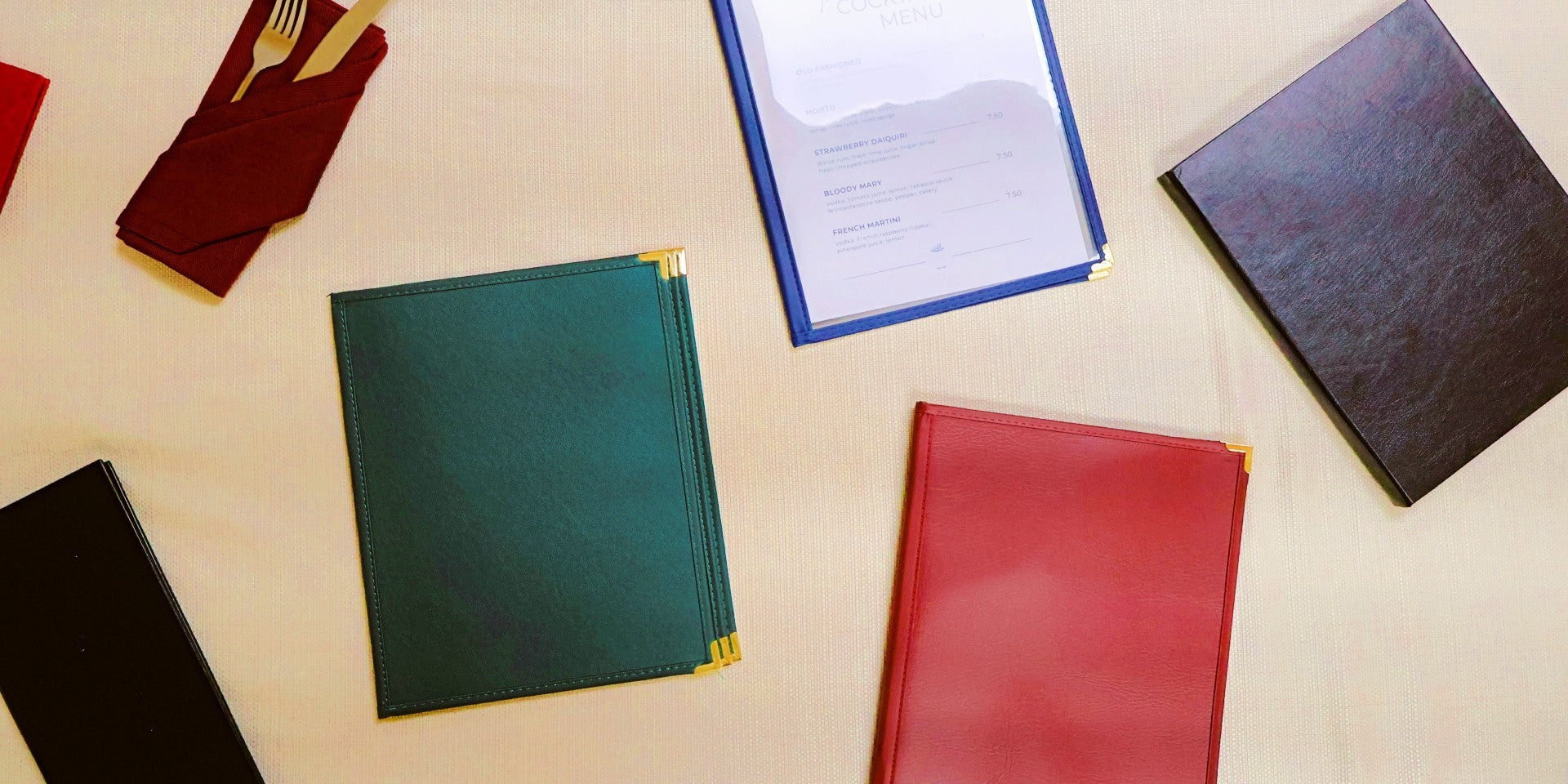 Colorful mixture of menu covers on a beige surface